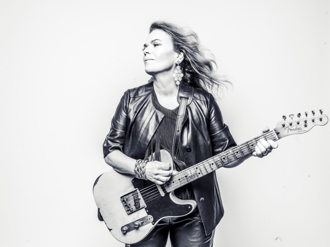 Australian singer-songwriter Paula Punch, wearing a leather jacket and playing a vintage Fender electric guitar.